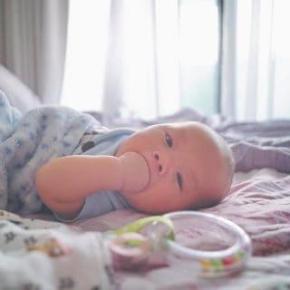 Baby lying down on the bed.