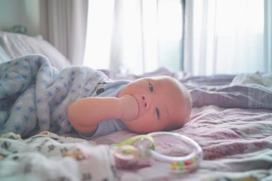 Baby lying down on the bed.